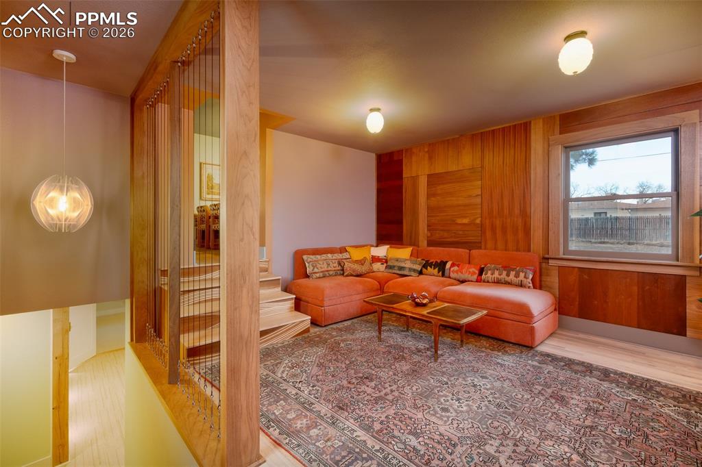 Family room with custom built paneling and custom built wood stairs up to the dining room