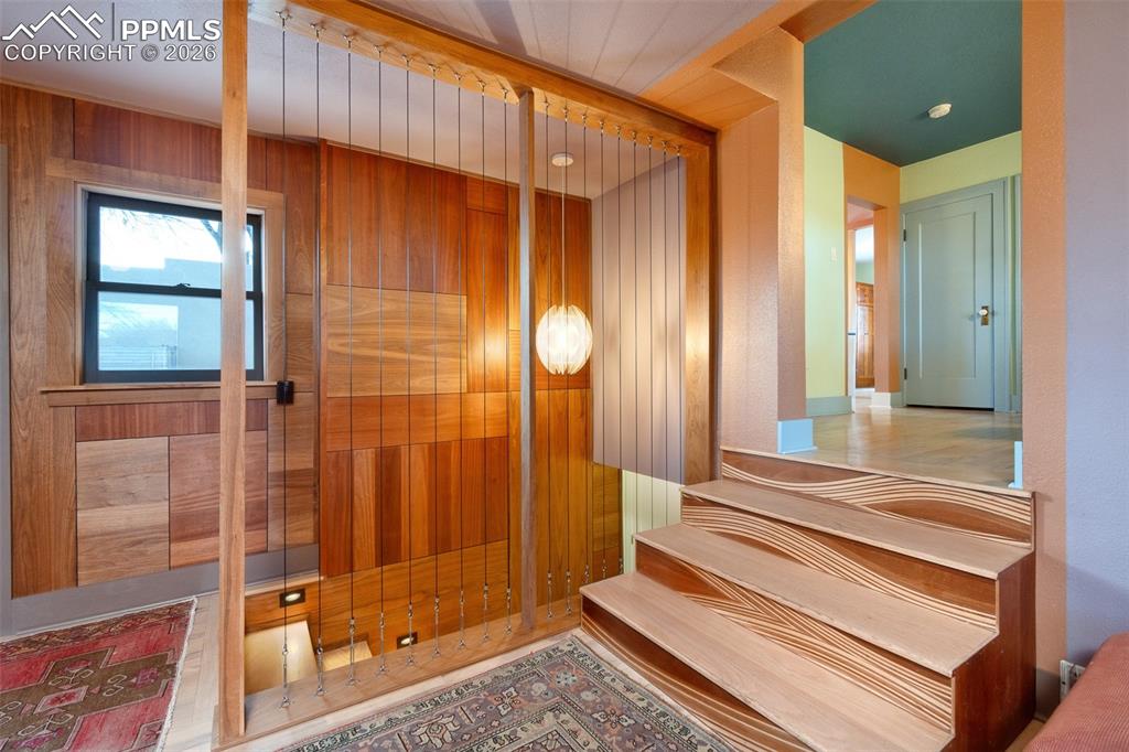 Custom wood paneling, custom wood stairs and room separator with vintage fixture. 