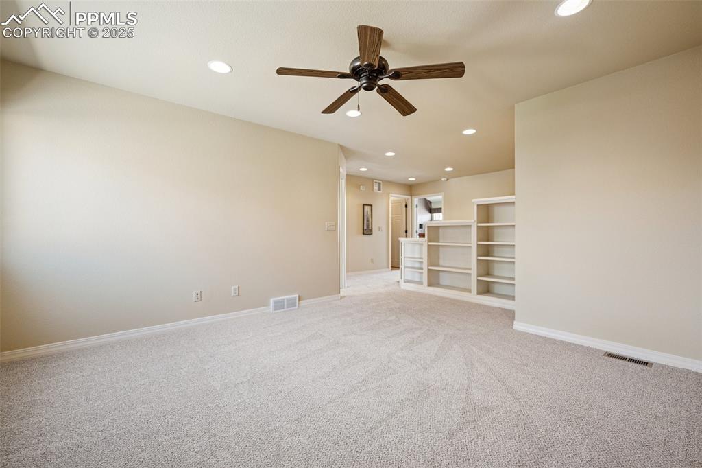 Empty room with ceiling fan, recessed lighting, and light carpet