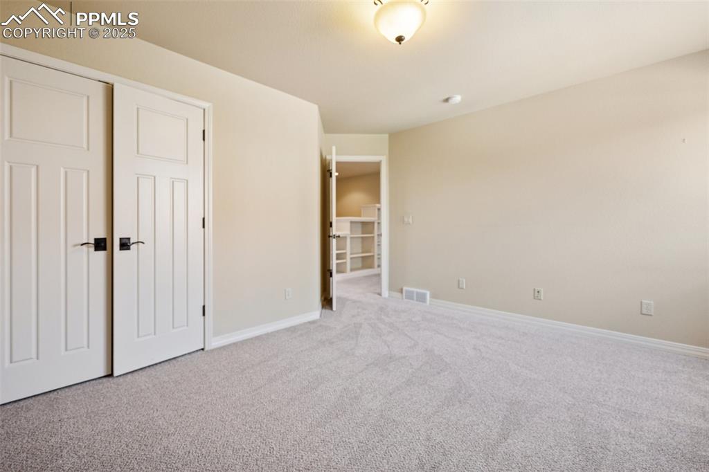 Unfurnished bedroom featuring carpet flooring and baseboards