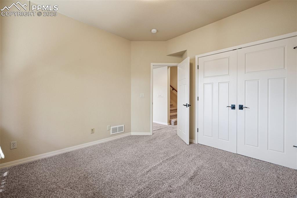 Unfurnished bedroom with carpet and a closet