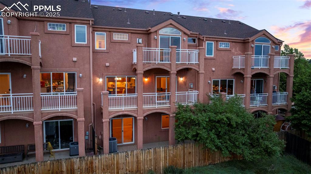 Back of property featuring stucco siding, a balcony, and roof with shingles