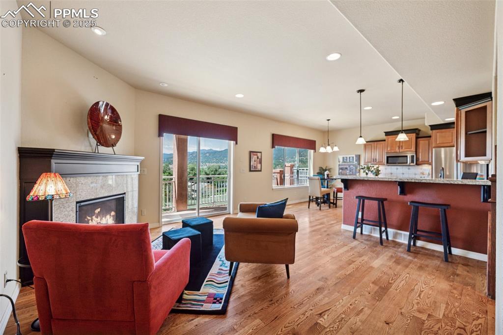 Living room featuring light wood-style flooring, recessed lighting, and a lit fireplace