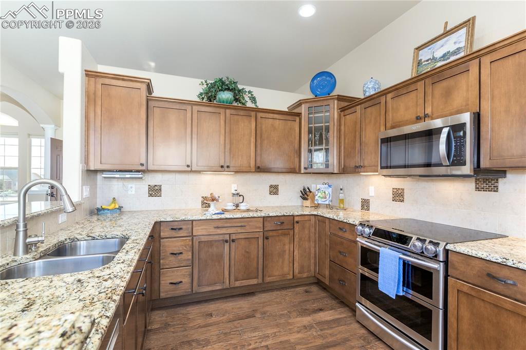 Granite slab counters, tile backsplash, stainless steel appliances, Samsung double oven, Whirlpool microwave and Bosch dishwasher.