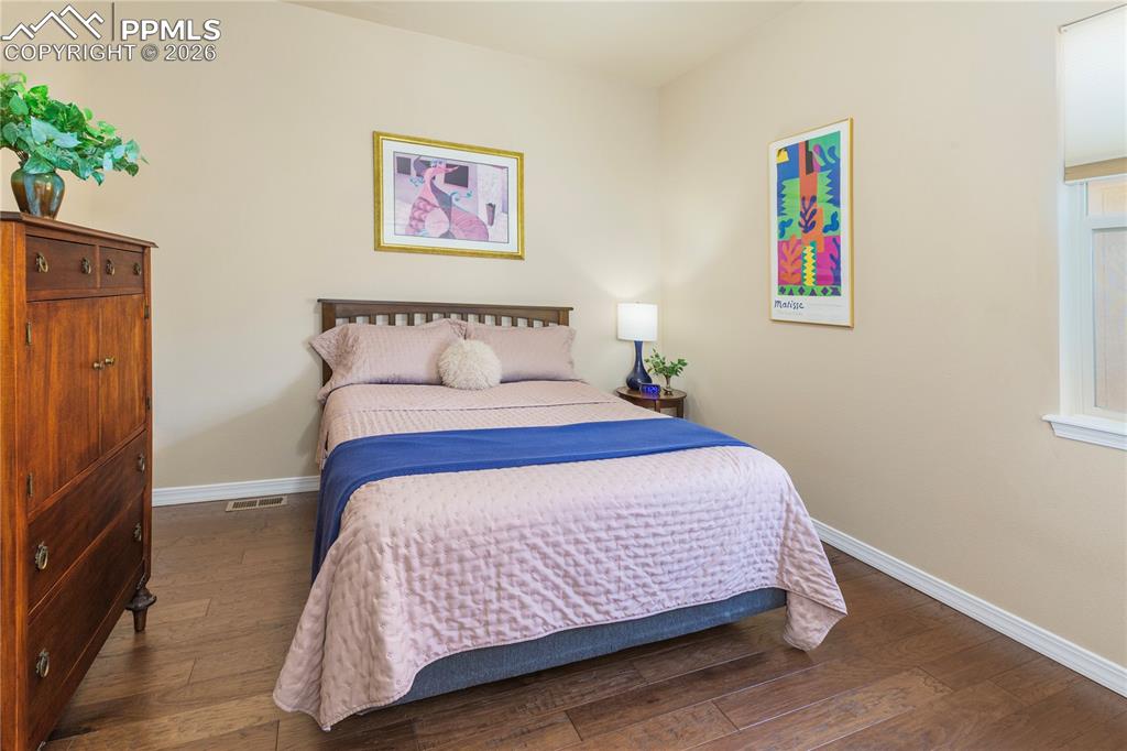 Main-level guest bedroom is adjacent to the full-size bathroom and includes custom closet shelving.