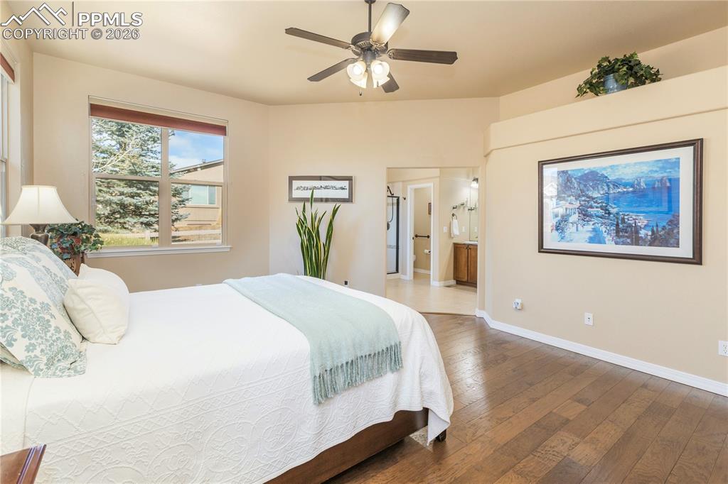 Bedroom with hardwood / wood-style flooring, a ceiling fan, and ensuite bathroom