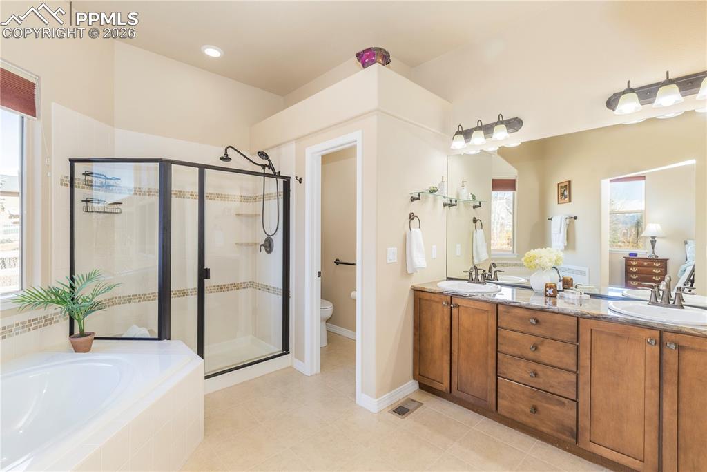 Oil-rubbed finishes throughout with a double vanity, granite counters, maple cabinets, and a large shower with bench seating.