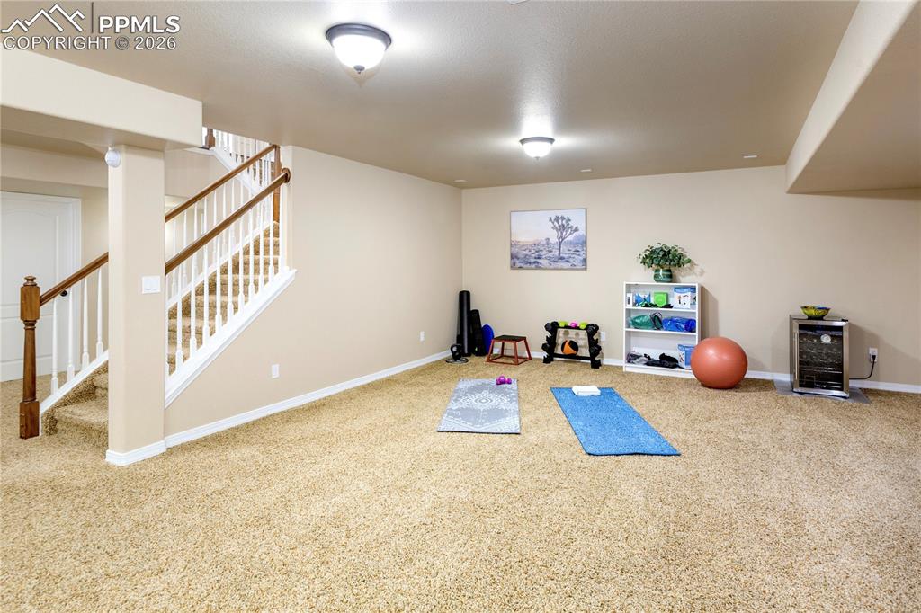 Workout area with light carpet and wine cooler