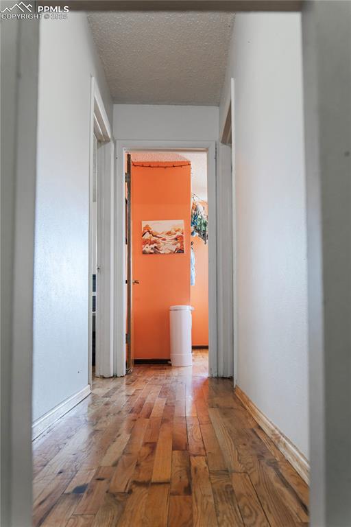 Hall featuring wood-type flooring and a textured ceiling
