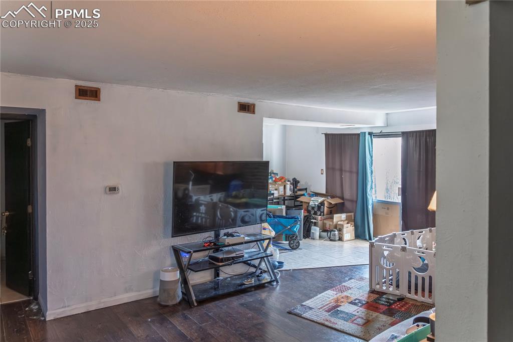 Living room featuring baseboards and dark wood-style flooring