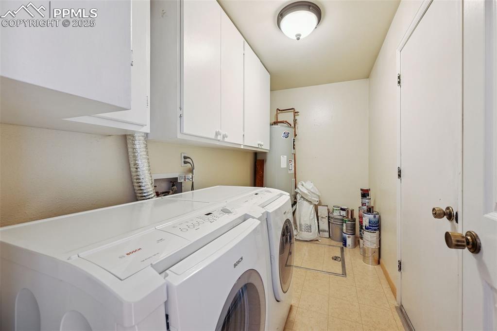 The laundry area includes extra cabinets and access to the crawl space. 