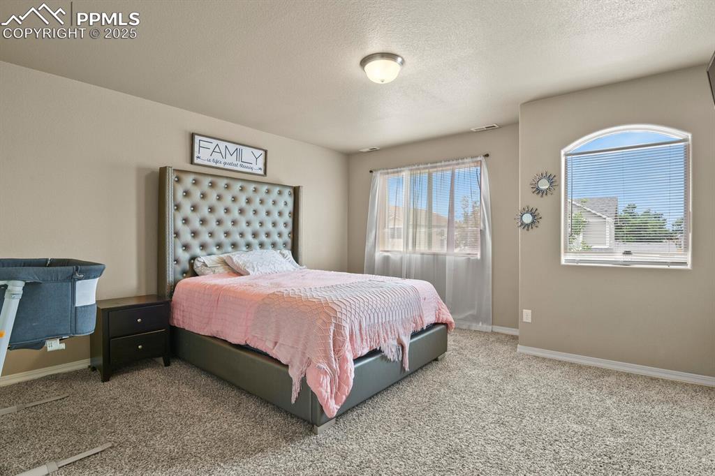 Bedroom with carpet and a textured ceiling