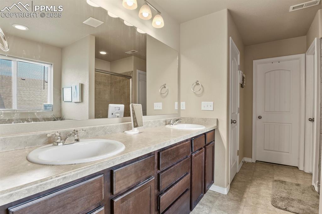 Bathroom with double vanity and a shower stall