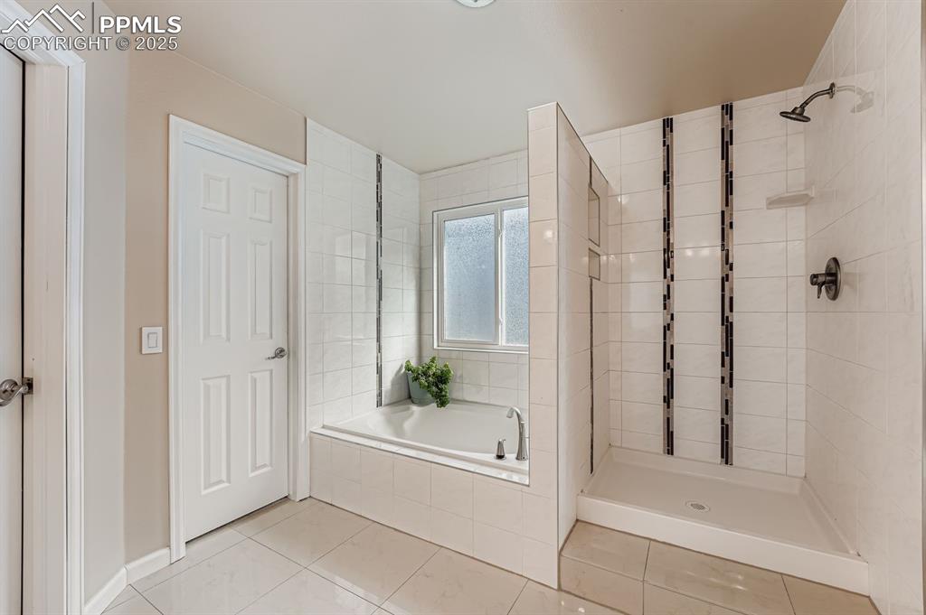 Full bathroom with a bath, a stall shower, and light tile patterned floors