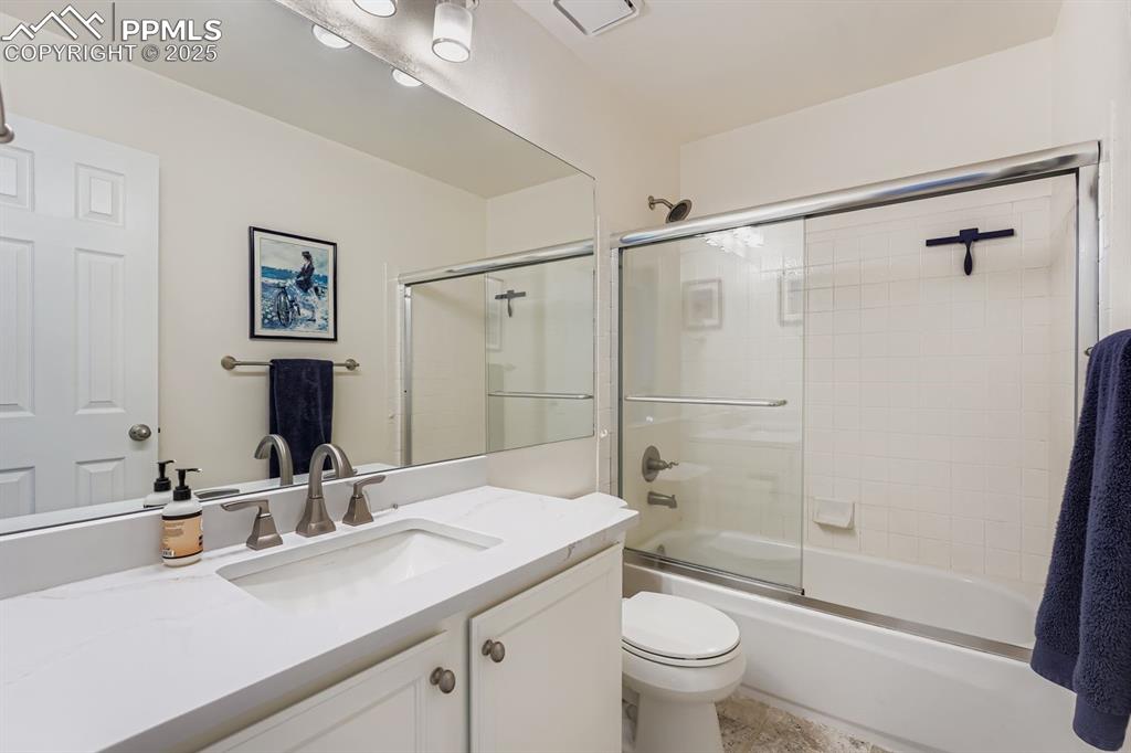 Bathroom featuring vanity and enclosed tub / shower combo