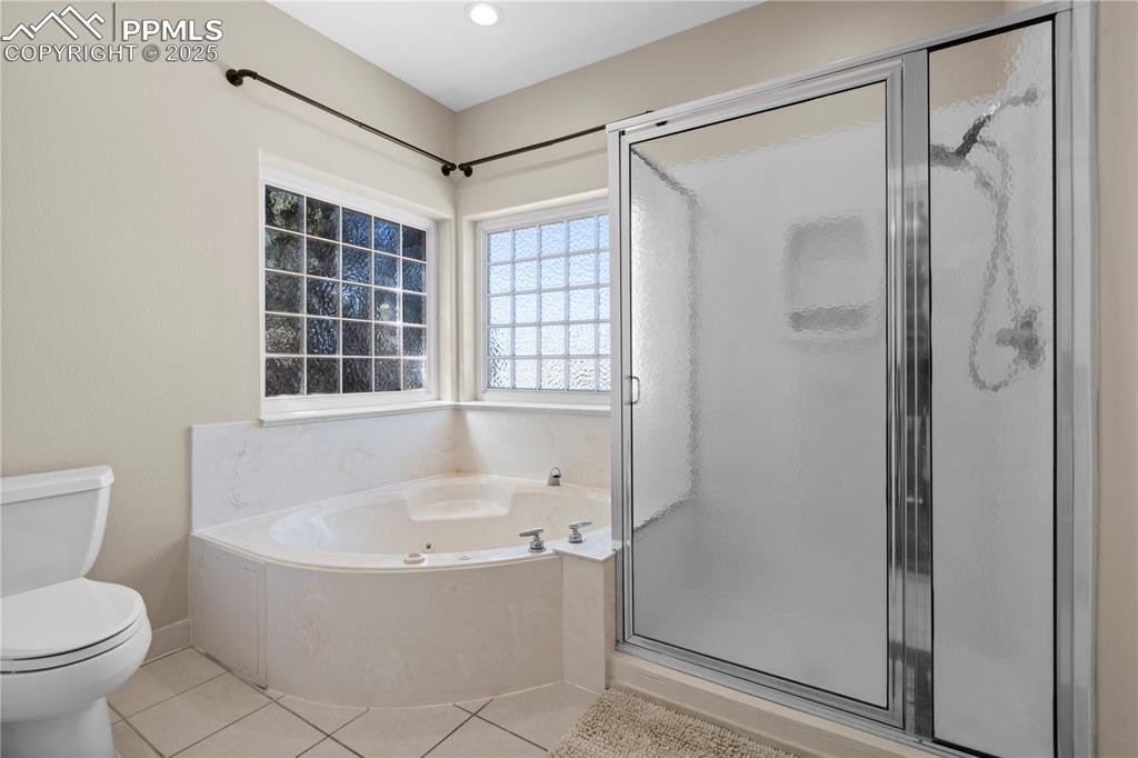 Full bath featuring a garden tub, a stall shower, and tile patterned floors