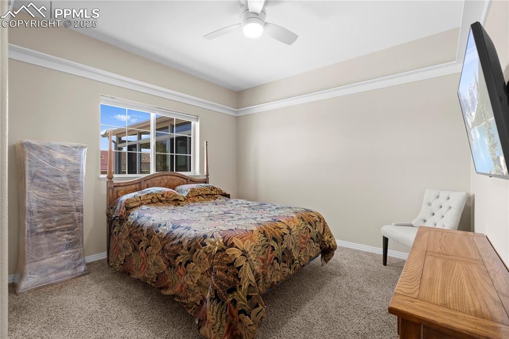 Carpeted bedroom featuring baseboards and a ceiling fan
