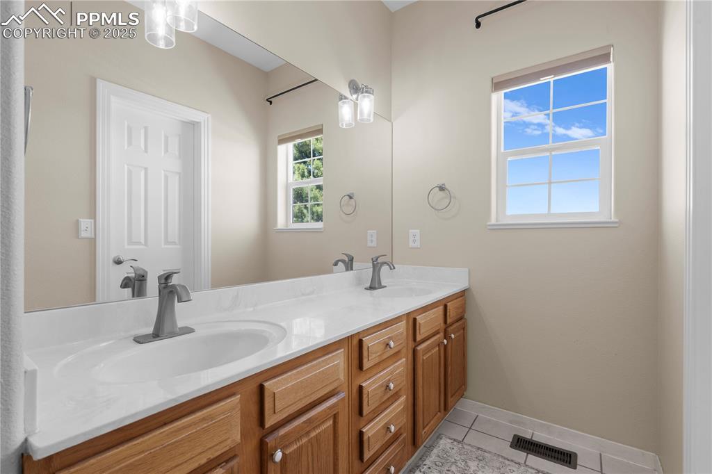 Bathroom with double vanity and tile patterned floors