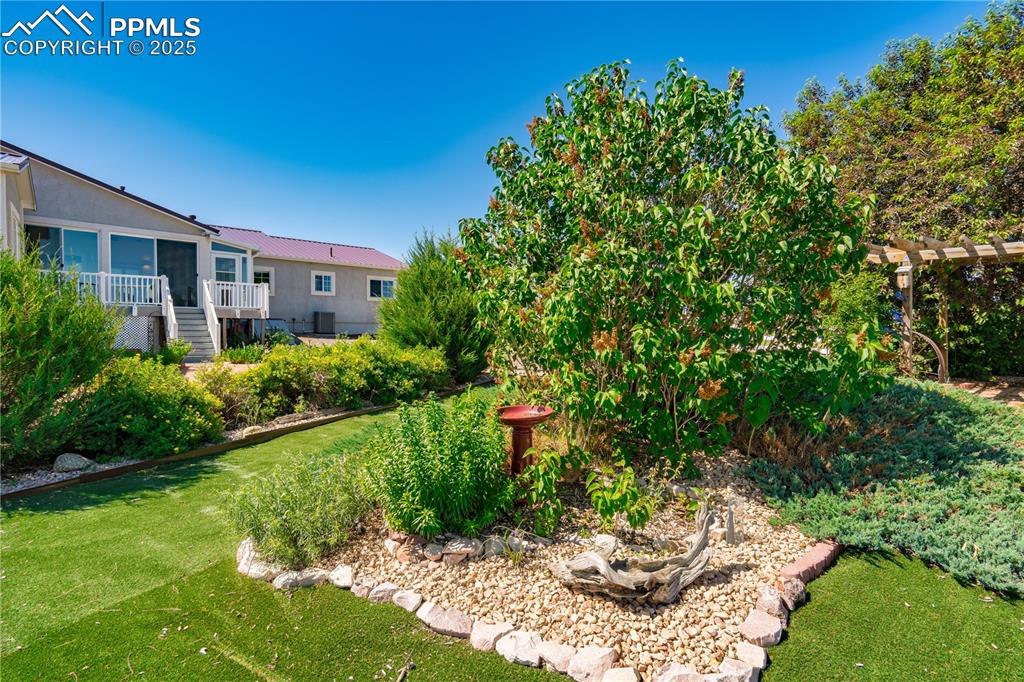 View of grassy yard with stairway and a wooden deck