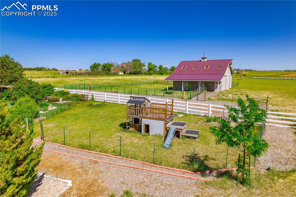 View of yard with an outdoor structure, a view of countryside, and an exterior structure