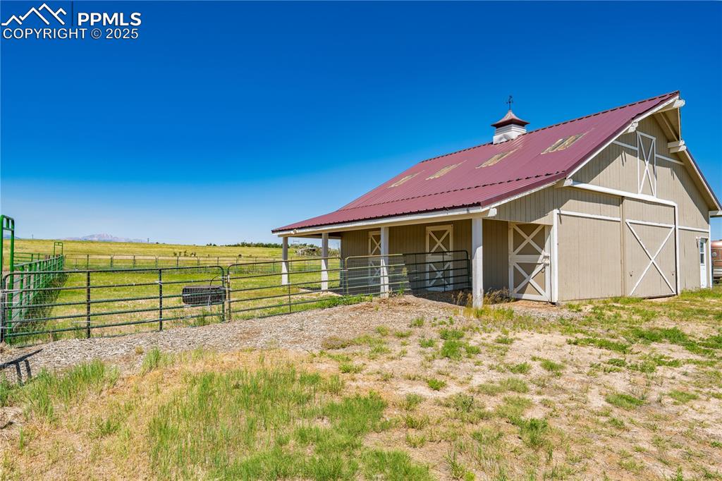 View of barn featuring an exterior structure and a rural view