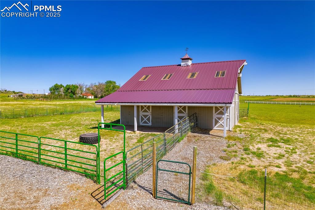 Back of house with an exterior structure, an outdoor structure, a metal roof, and a barn