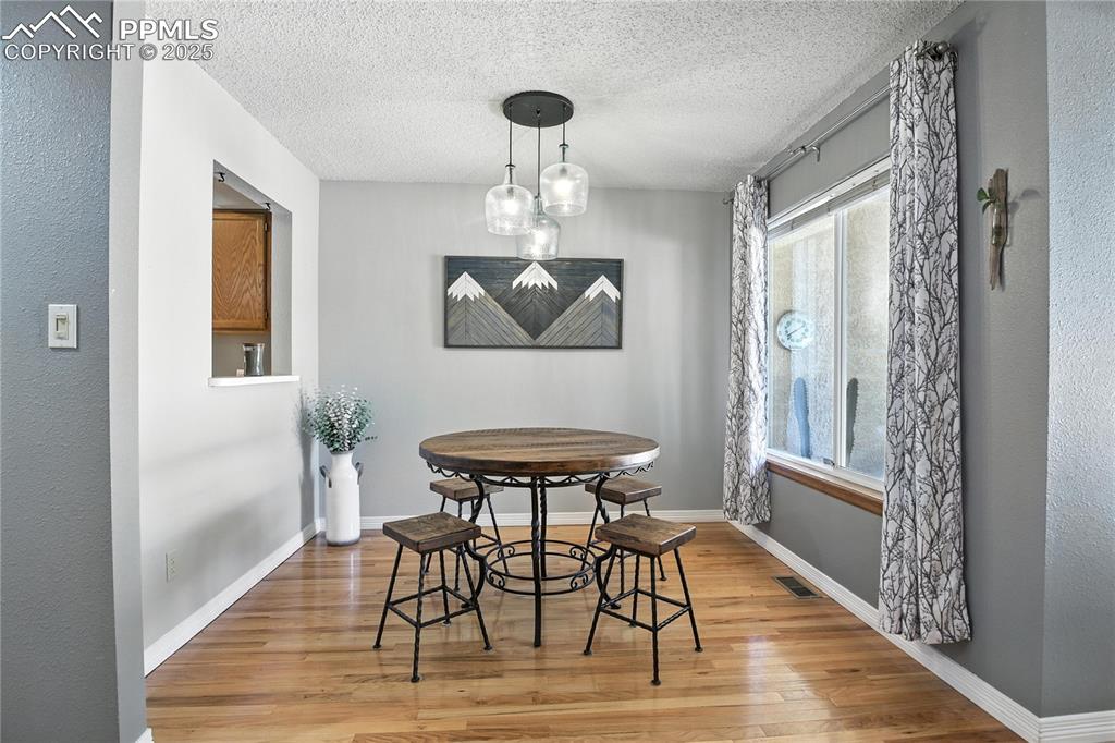 Dining area featuring light wood finished floors, stairway, and a textured ceiling