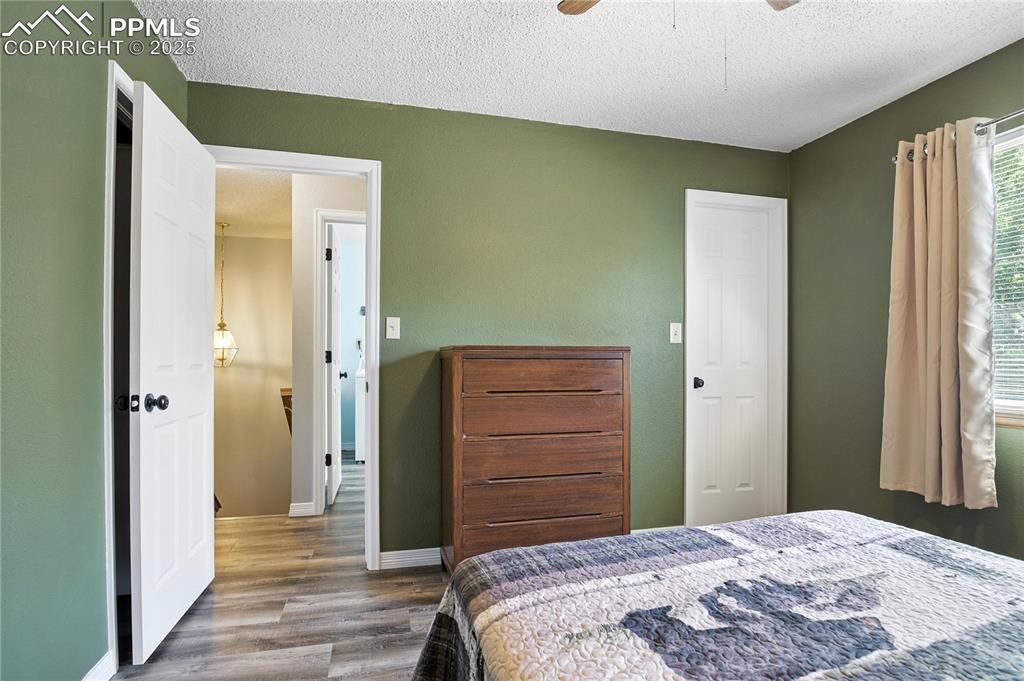 Bedroom featuring wood finished floors, a textured ceiling, and ceiling fan