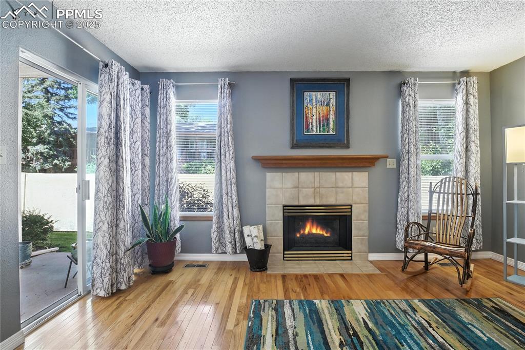 Spacious living room features a cozy gas fireplace and walks out to a private back patio