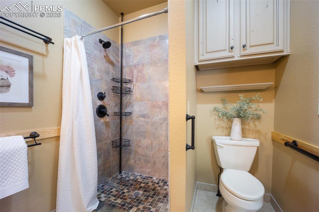 Full bath featuring a stall shower and a textured wall