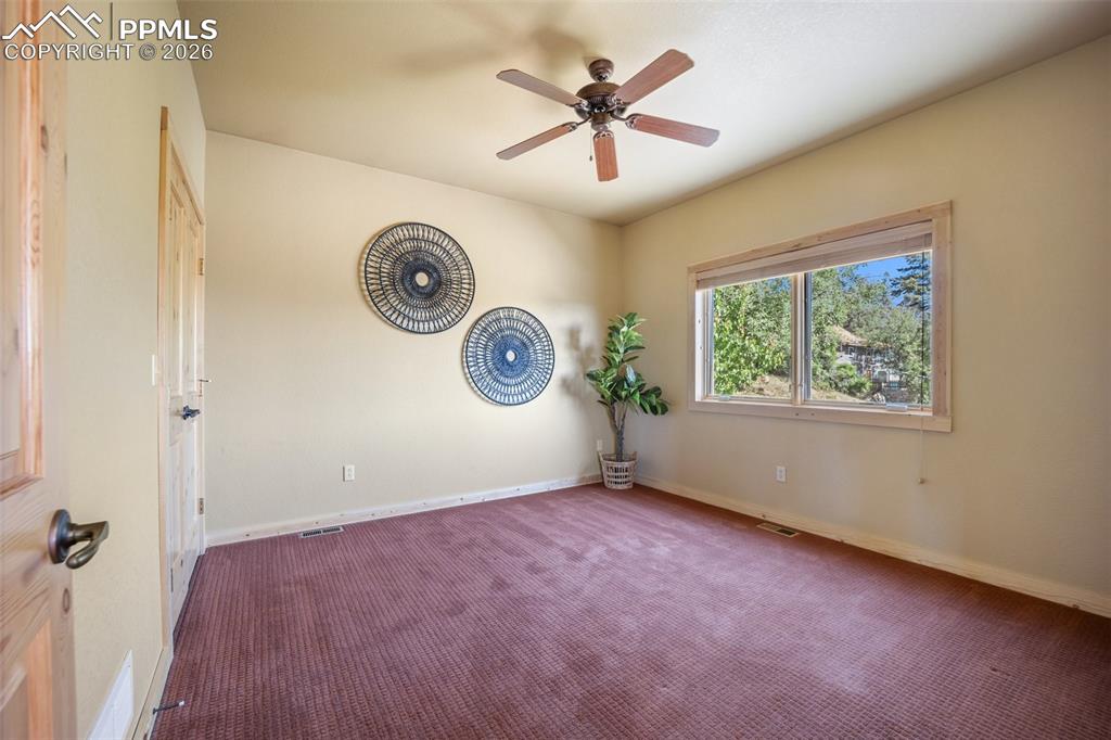 Carpeted spare room with baseboards and a ceiling fan