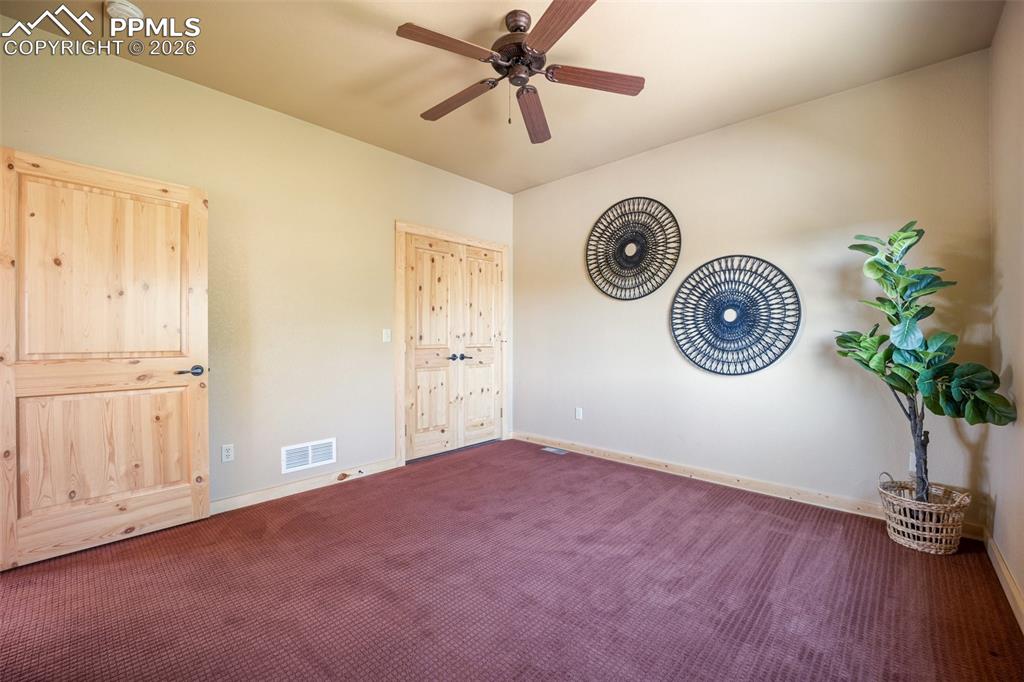 Unfurnished bedroom with carpet and a ceiling fan
