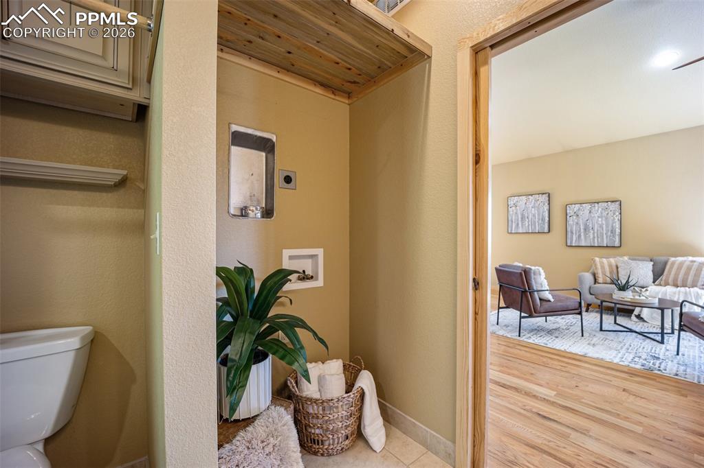 Corridor with light wood-style floors and a textured wall