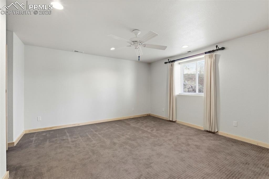 Spare room with dark colored carpet, recessed lighting, and ceiling fan