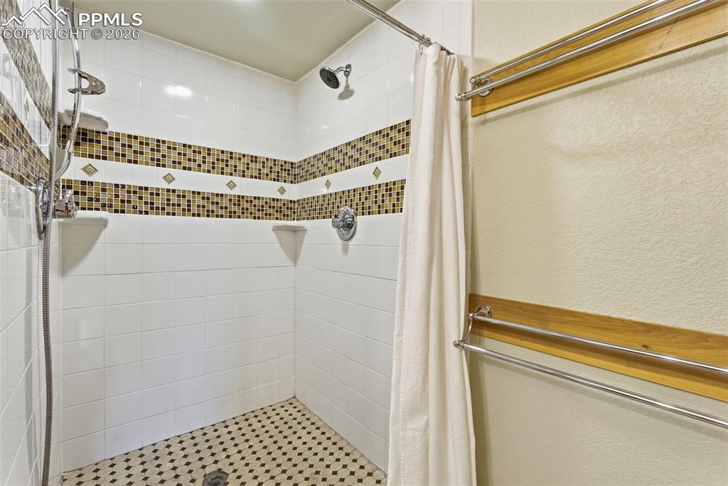 Full bath with a stall shower and a textured wall