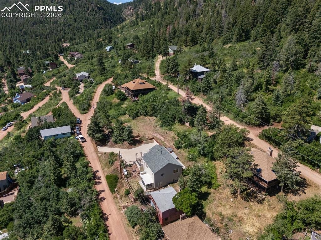 Aerial view of property and surrounding area featuring a forest