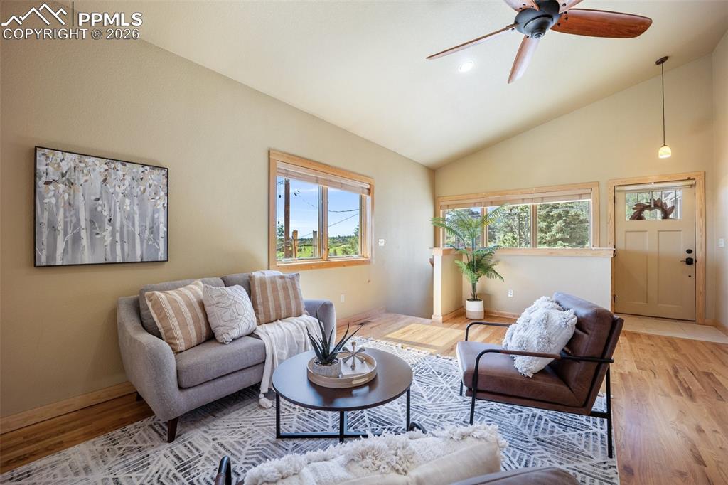 Living room with lofted ceiling, ceiling fan, plenty of natural light, light wood-style floors, and recessed lighting