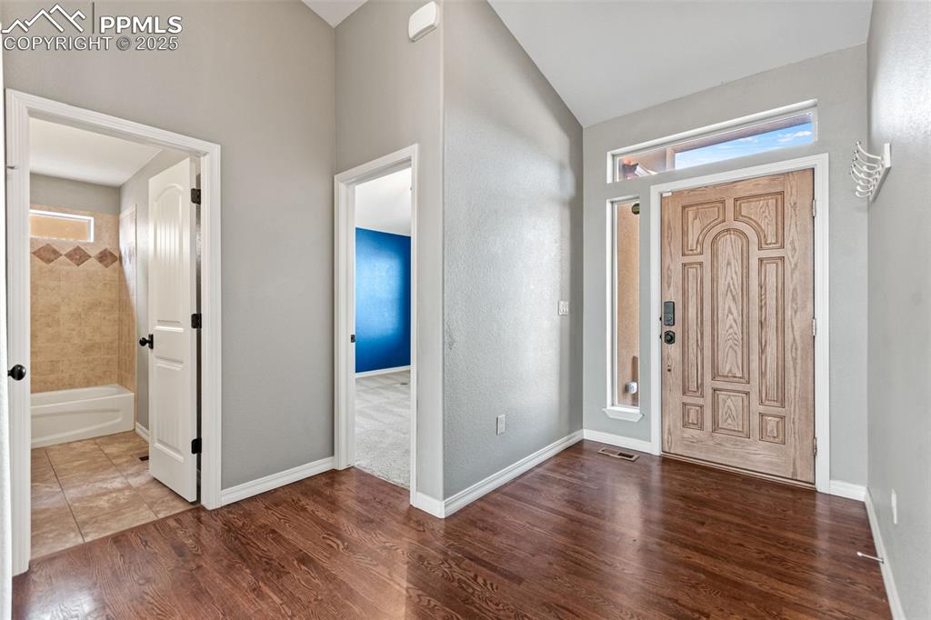 Entryway with dark wood-type flooring and baseboards