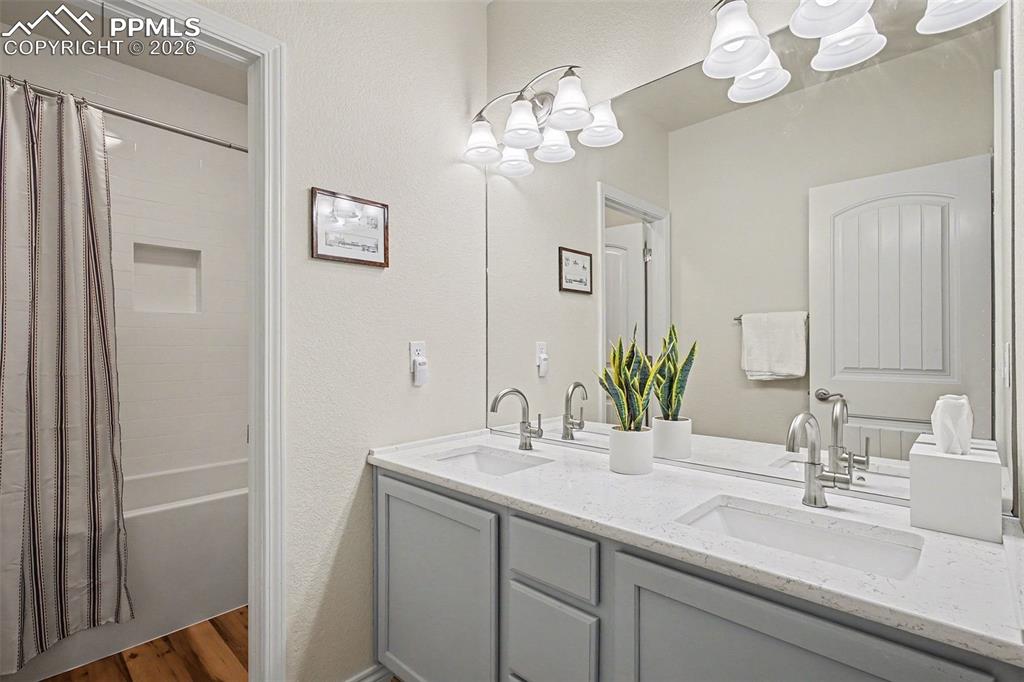 Full bathroom in basement with dual sinks