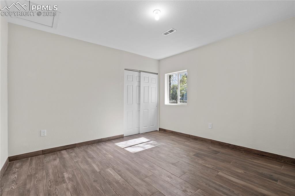 Unfurnished bedroom featuring wood finished floors and a closet