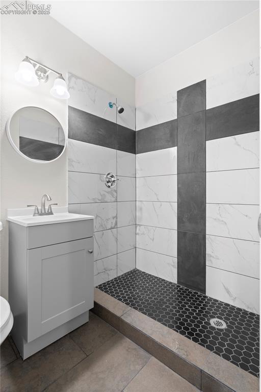 Bathroom with tiled shower and vanity