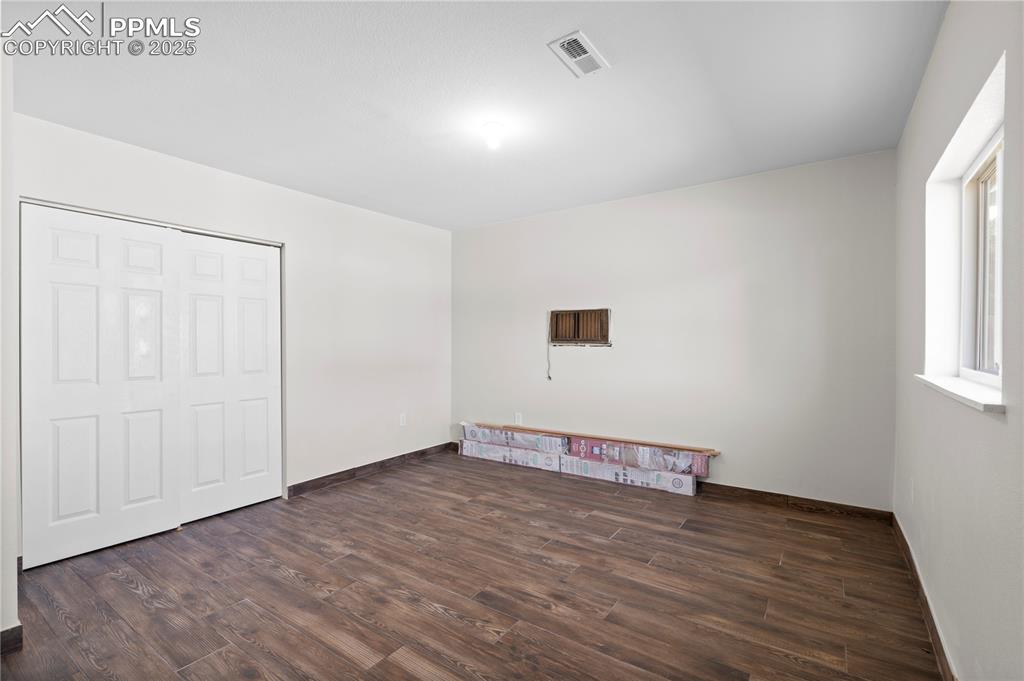 Unfurnished bedroom with wood finished floors and baseboards