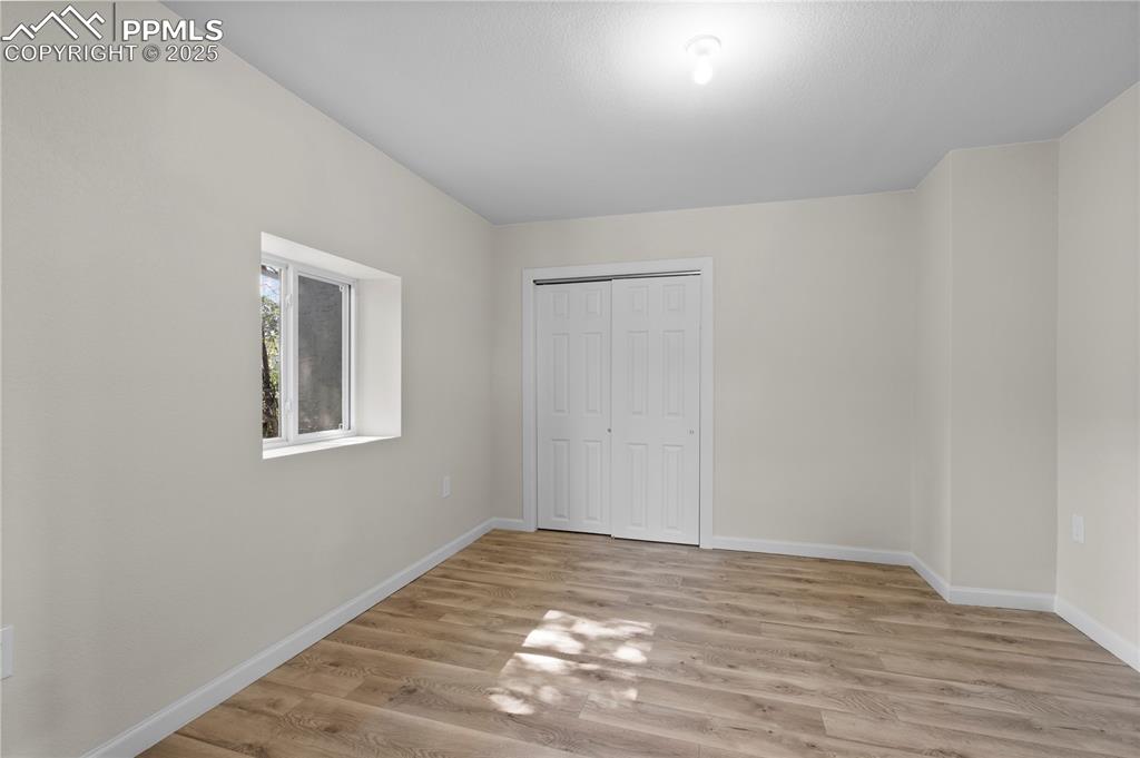 Unfurnished bedroom with light wood-style flooring and a closet