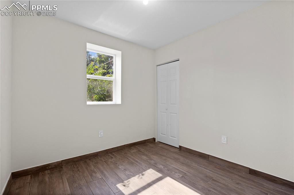 Empty room featuring wood finished floors and baseboards