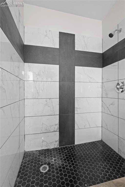 Full bath featuring tiled shower