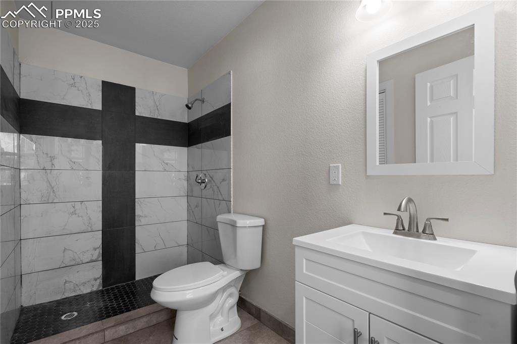 Bathroom with tiled shower and vanity