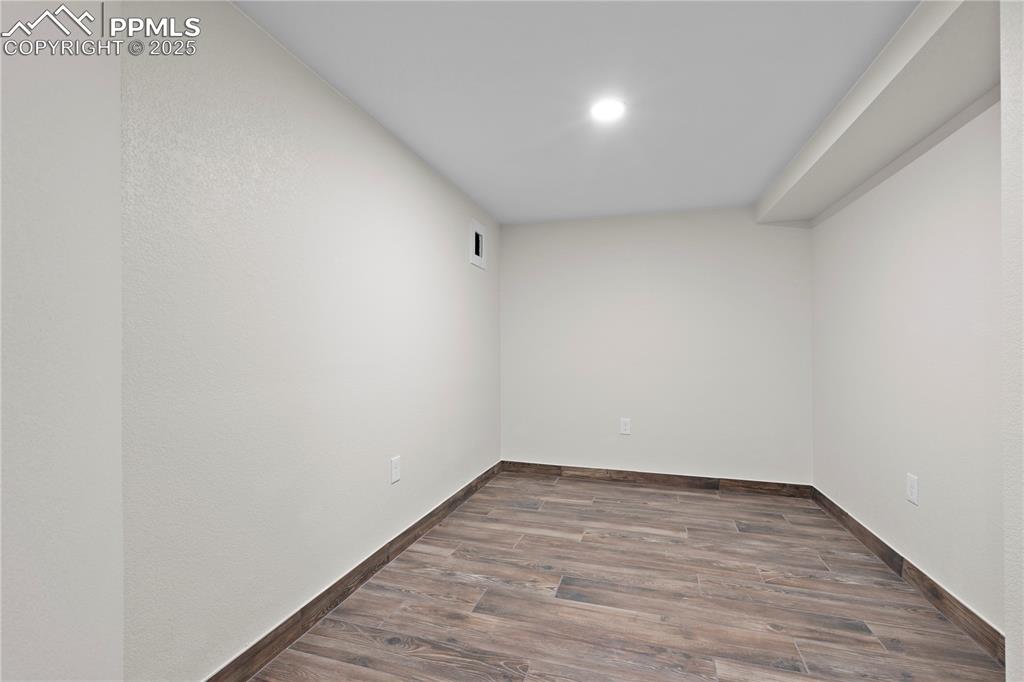 Unfurnished room with wood finished floors and baseboards