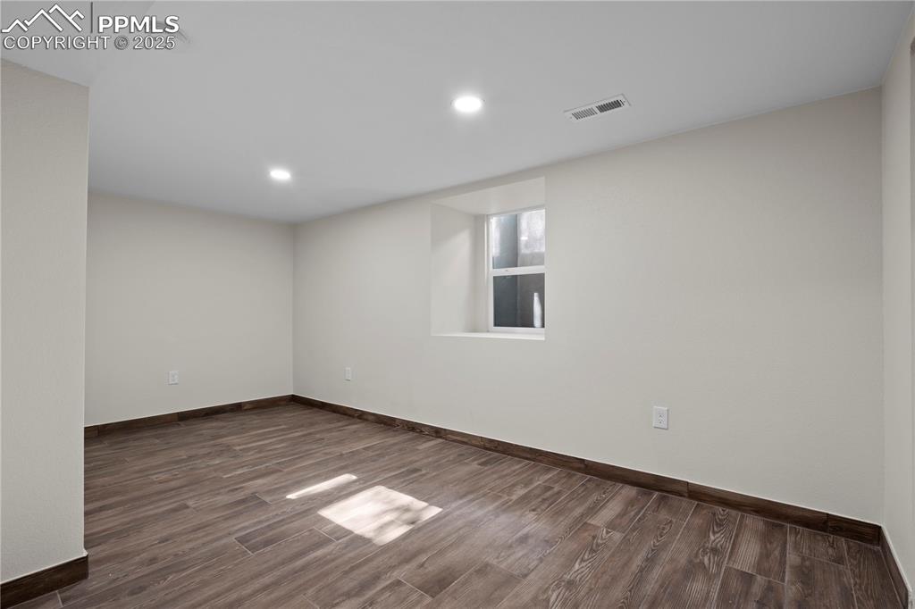 Spare room with dark wood-style flooring, recessed lighting, and a smoke detector