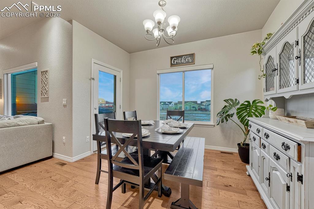 Dining area with light wood-style floors and a chandelier