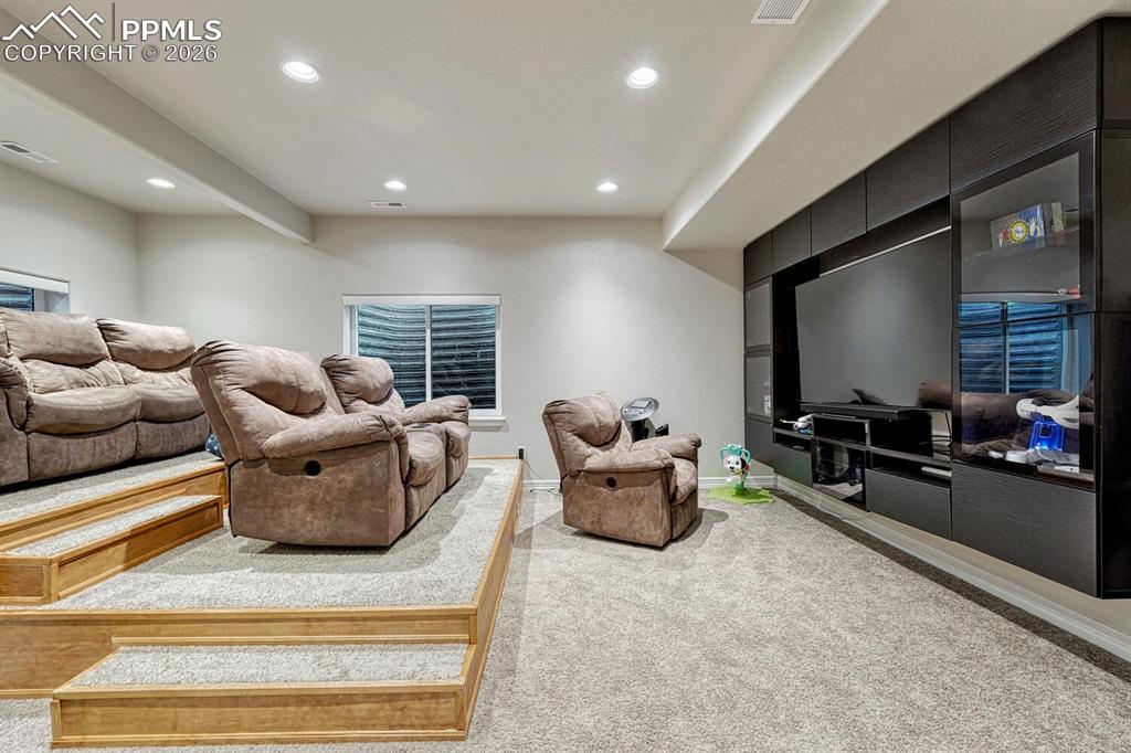 Living area featuring light carpet and recessed lighting